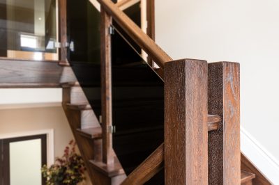 custom wood staircase with tinted glass railing